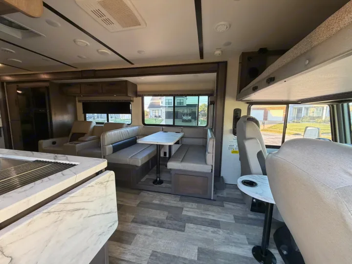 Modern RV rental interior: dinette, kitchen, lounge seating, and an overhead bunk. Ready for your road trips.. FR3 FR3 Motorhome 2022