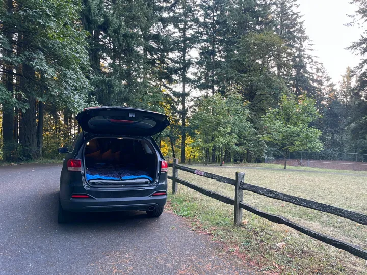 SUV car camping setup in a forest, offering an alternative to an RV rental for outdoor adventures.. KIA Sorento 4X4 2017