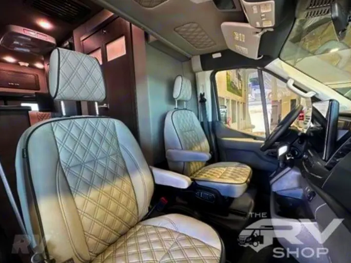 Spacious RV rental camper van interior. Features plush, quilted captain's seats, showing the cabin and living area.. Midwest Automotive Designs Passage 2024