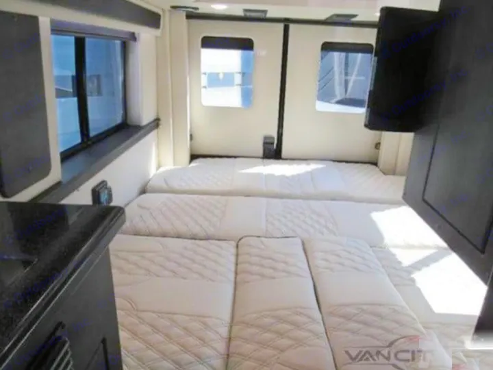 Vancit RV rental: cozy interior with a spacious bed, windows, and a kitchen counter. Ready for adventure!. Midwest Automotive Designs Passage 2024