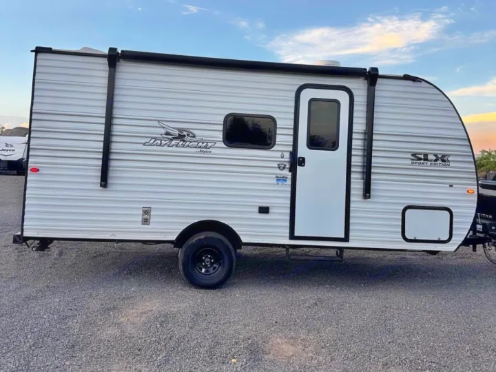 RV rental: A white Jayco Jay Flight SLX Sport Edition travel trailer parked on gravel under a blue sky, ready for adventure.. Jayco Jay Flight 2025
