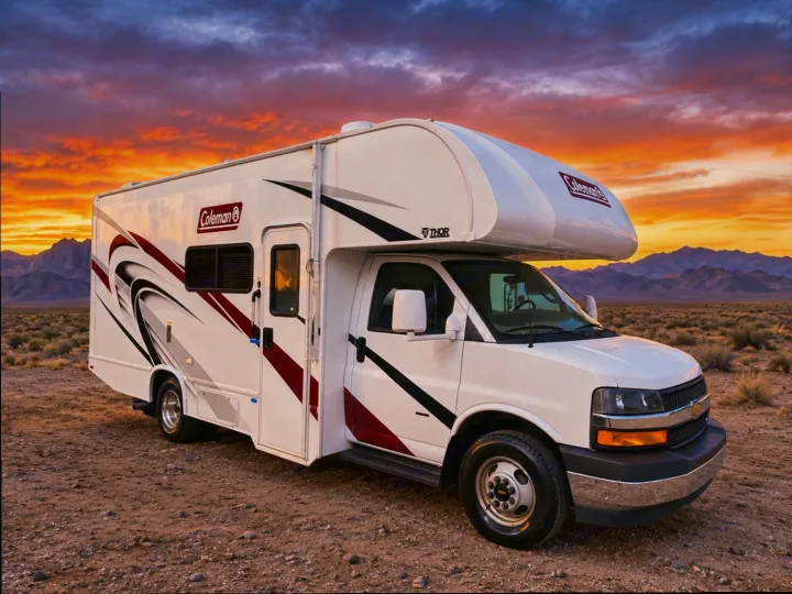 White Coleman rv rental parked in a desert landscape under a breathtaking sunset. Mountains frame this perfect scene for your next adventure.. Thor Motor Coach Other 2024