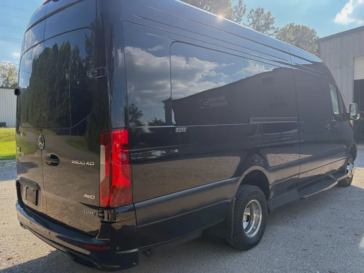 A black Mercedes-Benz Sprinter 3500XD AWD LUXE van, reflecting sky, ideal for a luxury rv rental experience.. Midwest Automotive Designs Luxe Cruiser 2025