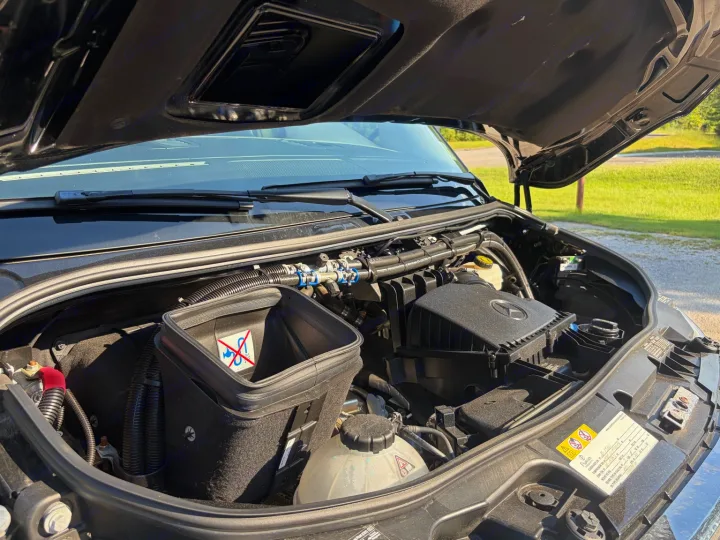 Open hood of an RV rental, revealing a Mercedes-Benz engine bay with air filter and fluid reservoirs for pre-trip checks.. Midwest Automotive Designs Luxe Cruiser 2025
