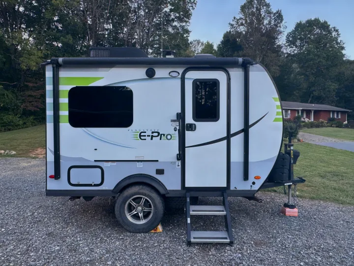 This white and green Flagstaff E-Pro travel trailer, perfect for an RV rental, is parked on a gravel driveway.. Forest River Flagstaff E-Pro 2019