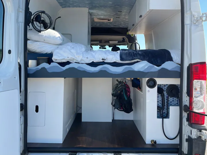 RV rental: Van interior with a cozy bed, under-bed storage, and tiled shower, offering comfort for mobile adventures.. Dodge Ram Promaster 2500 2014