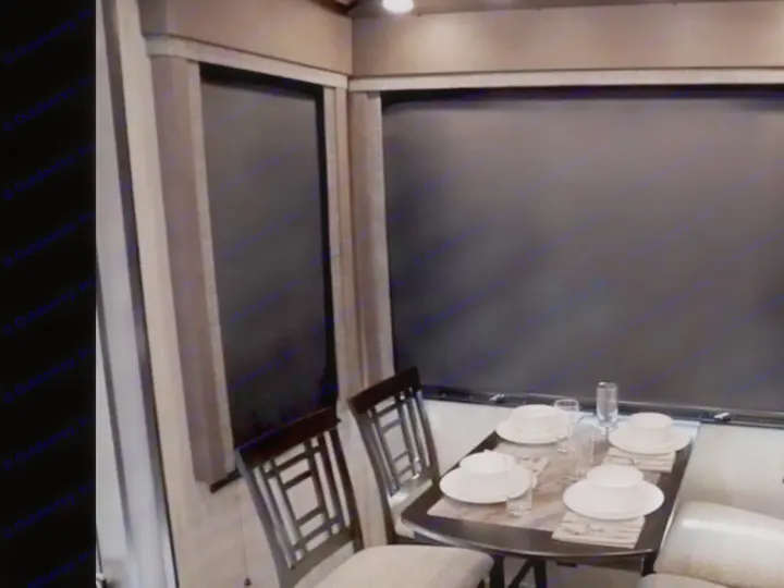 Cozy rv rental dining area featuring a table set for four, comfortable seating, and privacy blinds. Ideal for your next road trip.. Grand Design Momentum Toy Hauler 2020