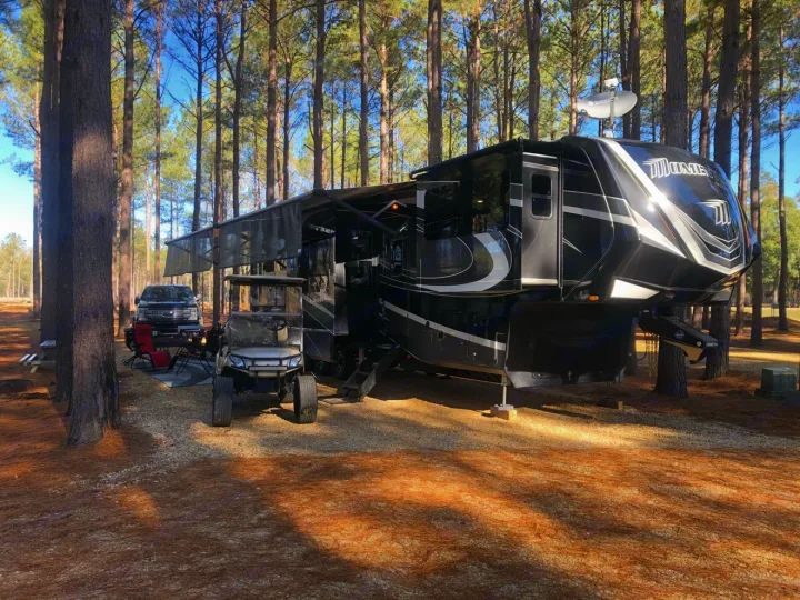 Get away with an RV rental! Modern fifth-wheel, truck, & golf cart set up in a peaceful pine forest campground.. Grand Design Momentum Toy Hauler 2020