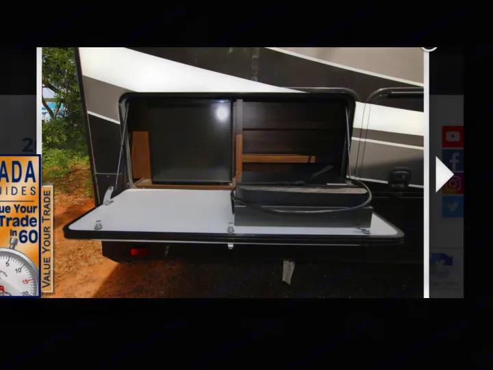 RV rental outdoor kitchen setup: a mini-fridge, shelves, and tabletop with a cooktop provide convenience for camping.. Grand Design Momentum Toy Hauler 2020