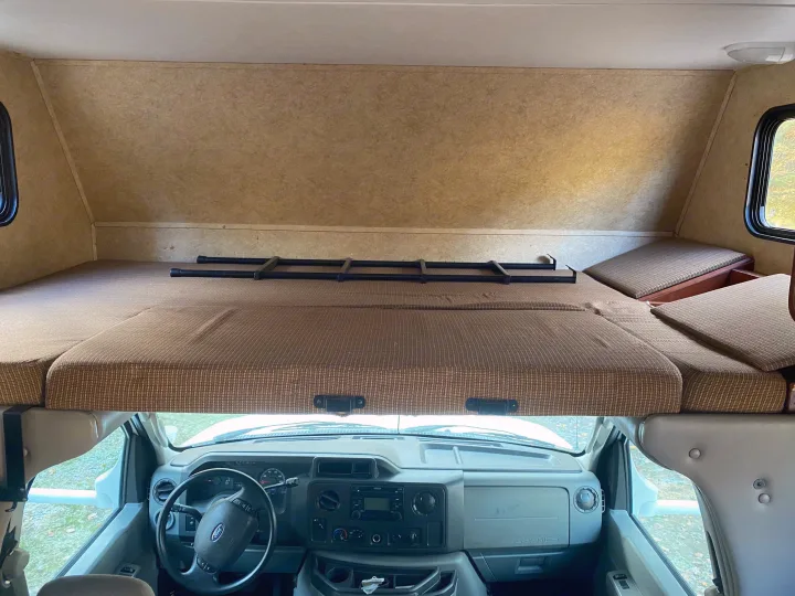 RV rental interior: Overhead bunk bed with ladder, looking down into the driver's cabin. Offers extra sleeping.. Forest River Sunseeker 2011