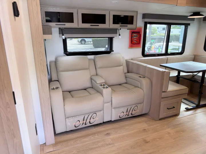 Modern RV rental interior features dual recliners with cup holders & a dinette, offering comfort and convenience.. Forest River 2706BH 2026