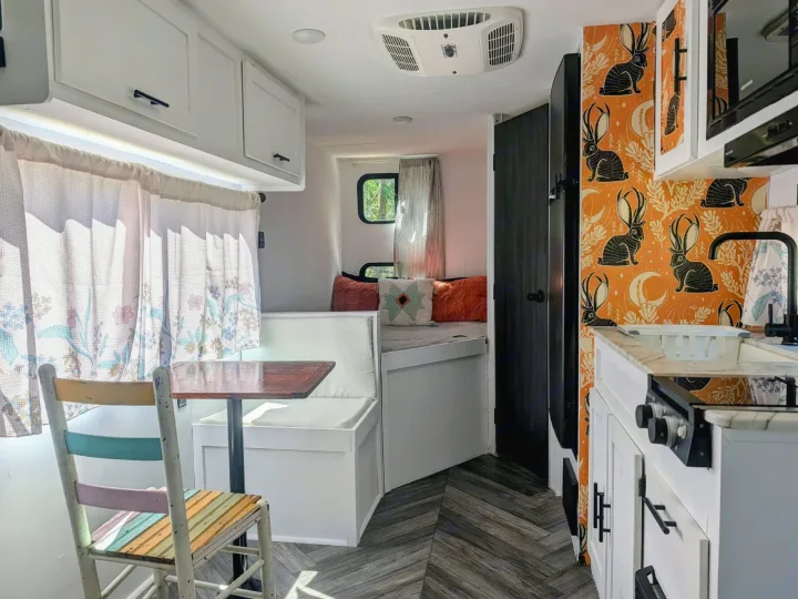 Step inside this inviting rv rental! Features a kitchenette, dining nook, and cozy sleeping area with vibrant decor.. Forest River Salem FSX Plantium 2022
