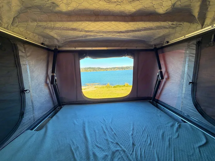 Cozy rooftop tent interior with a scenic lake view, perfect for your next rv rental adventure.. Dodge RAM Promaster 3500 2020