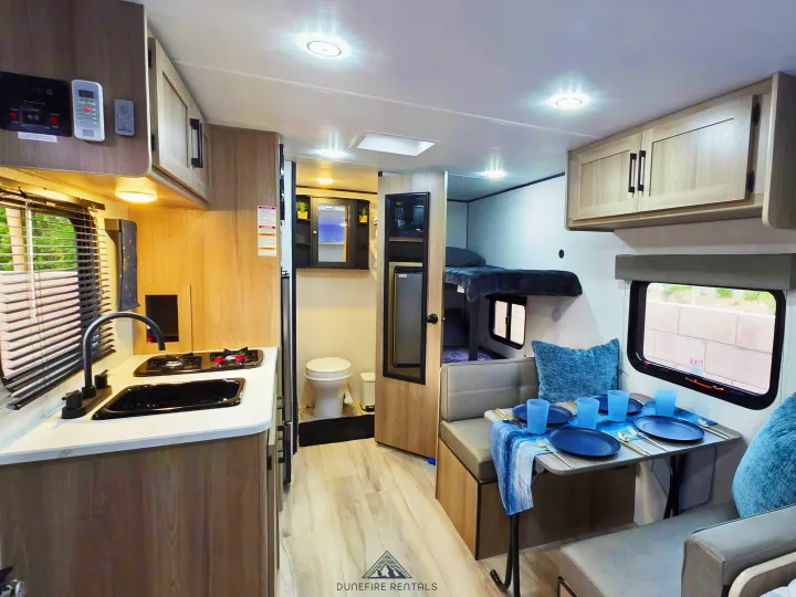 Experience this RV rental's bright interior: kitchen, dinette, bunk beds, bathroom, and AC for comfort.. Keystone Coleman 17B 2025
