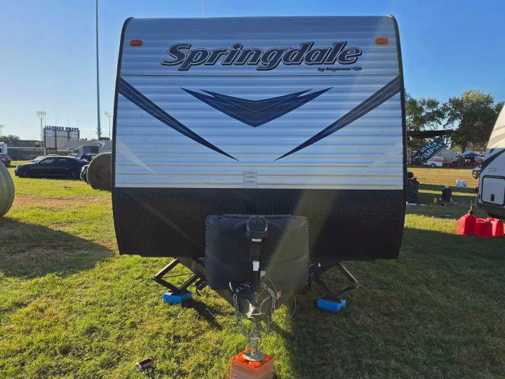 Front view of a Springdale by Keystone travel trailer, an RV rental, set up on grass. Perfect for camping or events.. Keystone RV Springdale SSR 2018