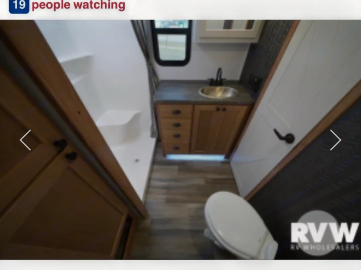 Compact RV rental bathroom: shower stall, wooden vanity with sink, and toilet visible. Perfect for road trips.. Forest River XLR Nitro Toy Hauler 2023
