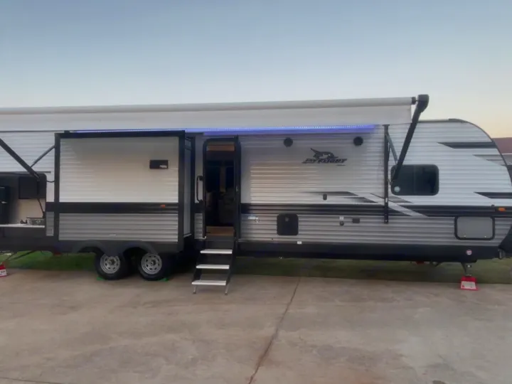 Experience camping with this spacious Jay Flight rv rental, featuring an extended awning and open door.. Jayco Jay Flight 2023