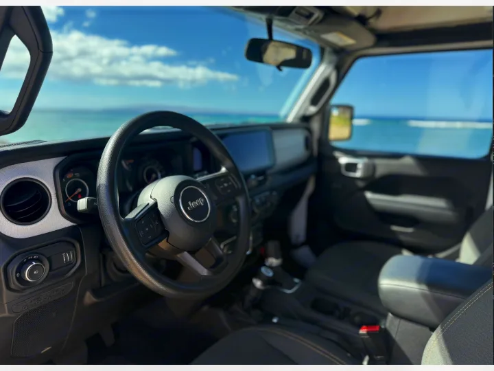 Jeep interior with ocean vista, suggesting a perfect rv rental road trip. Ideal for adventure and exploring coastal views.. Jeep Wrangler 2025