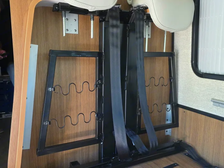 RV rental interior showing fold-down seats with headrests, seatbelts, and a window for versatile travel.. Roadtrek PIVOT SLUMBER 2024