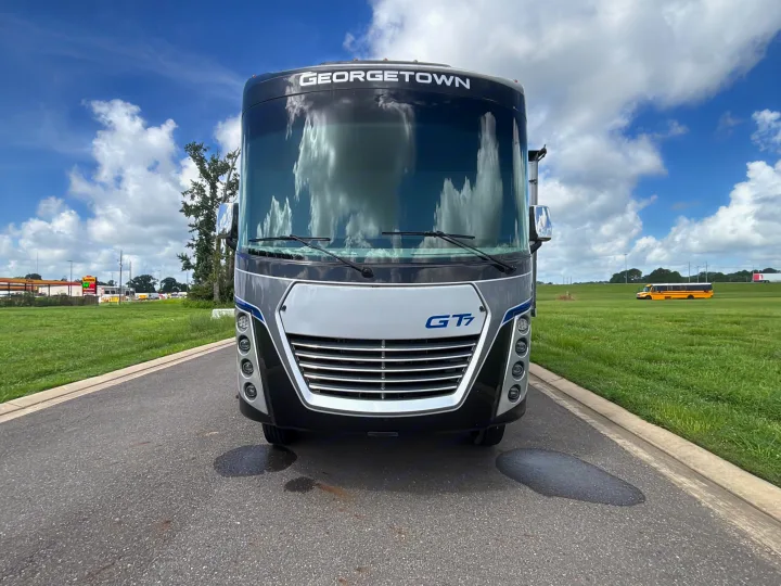 This Georgetown GT7 motorhome RV rental awaits adventure, parked on a road with green fields and a cloudy sky.. Georgetown GT7 2022