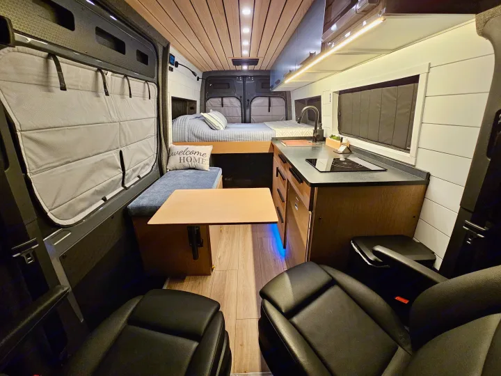 Step into this modern rv rental! Features a comfy bed, kitchen, dining area, and front cabin seats.. Mercedes-Benz Sprinter 2023