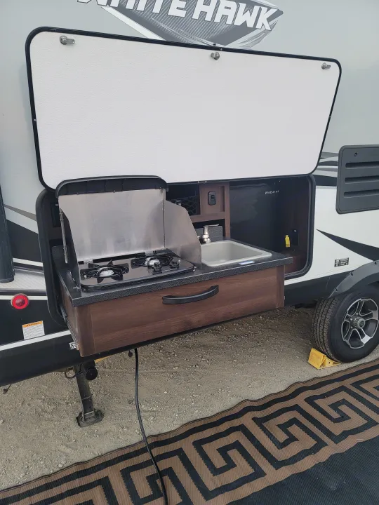 Outdoor Kitchen includes stove, sink and electric mini fridge. . Jayco White Hawk 2019