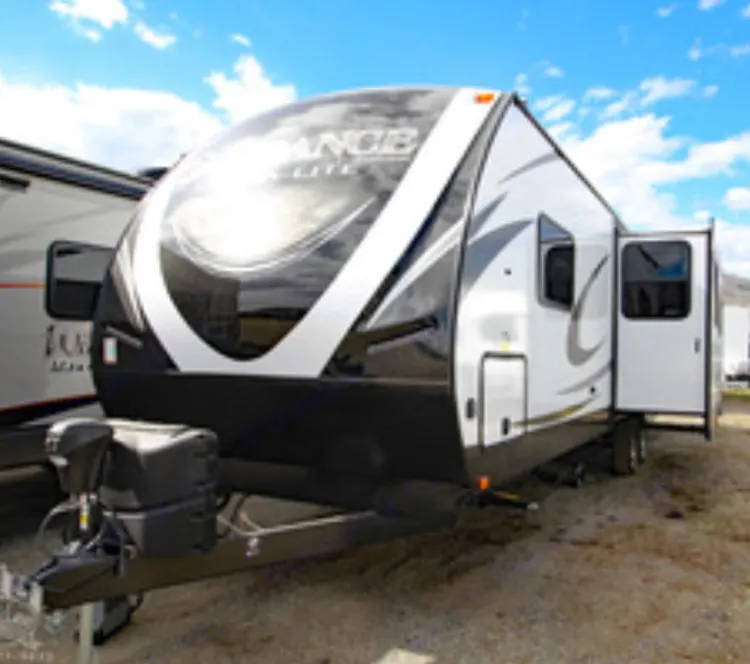 White and black Endurance travel trailer with open door, parked outdoors. Ideal for your next RV rental adventure.. Heartland Sundance 2019