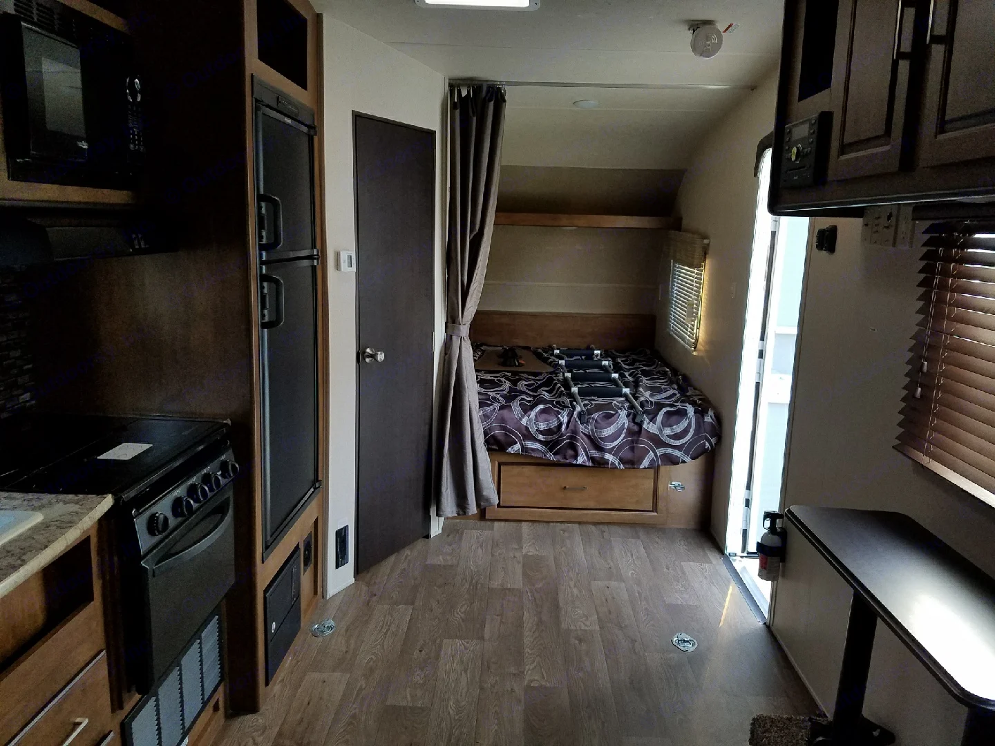 Explore this compact RV rental interior: complete kitchen, private bedroom, and small dining table. Ideal for road trips.. Forest River Salem Cruise Lite 2018