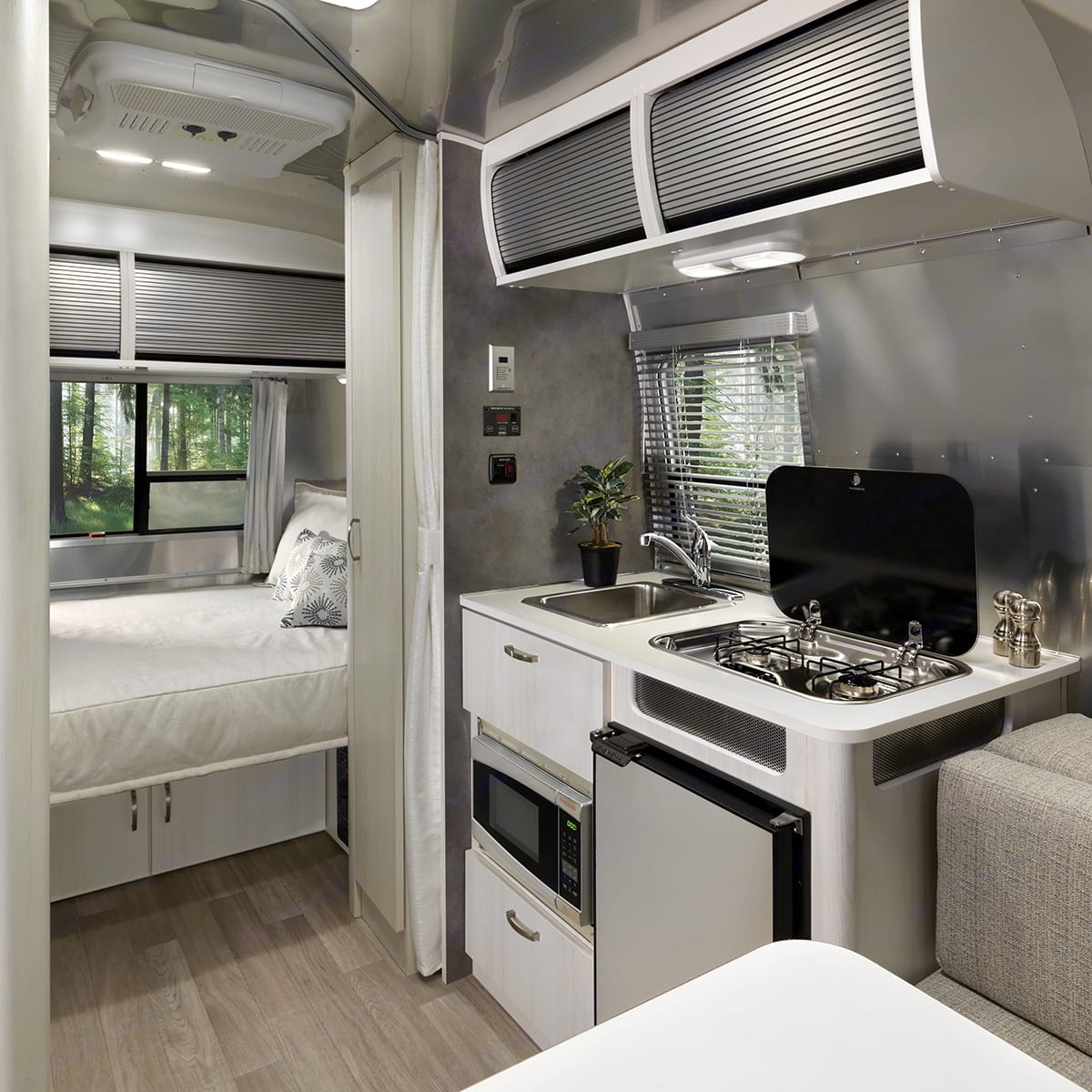 Kitchen with sink, 2 burner gas stove, fridge, microwave and tons of storage. . Airstream Bambi 2021
