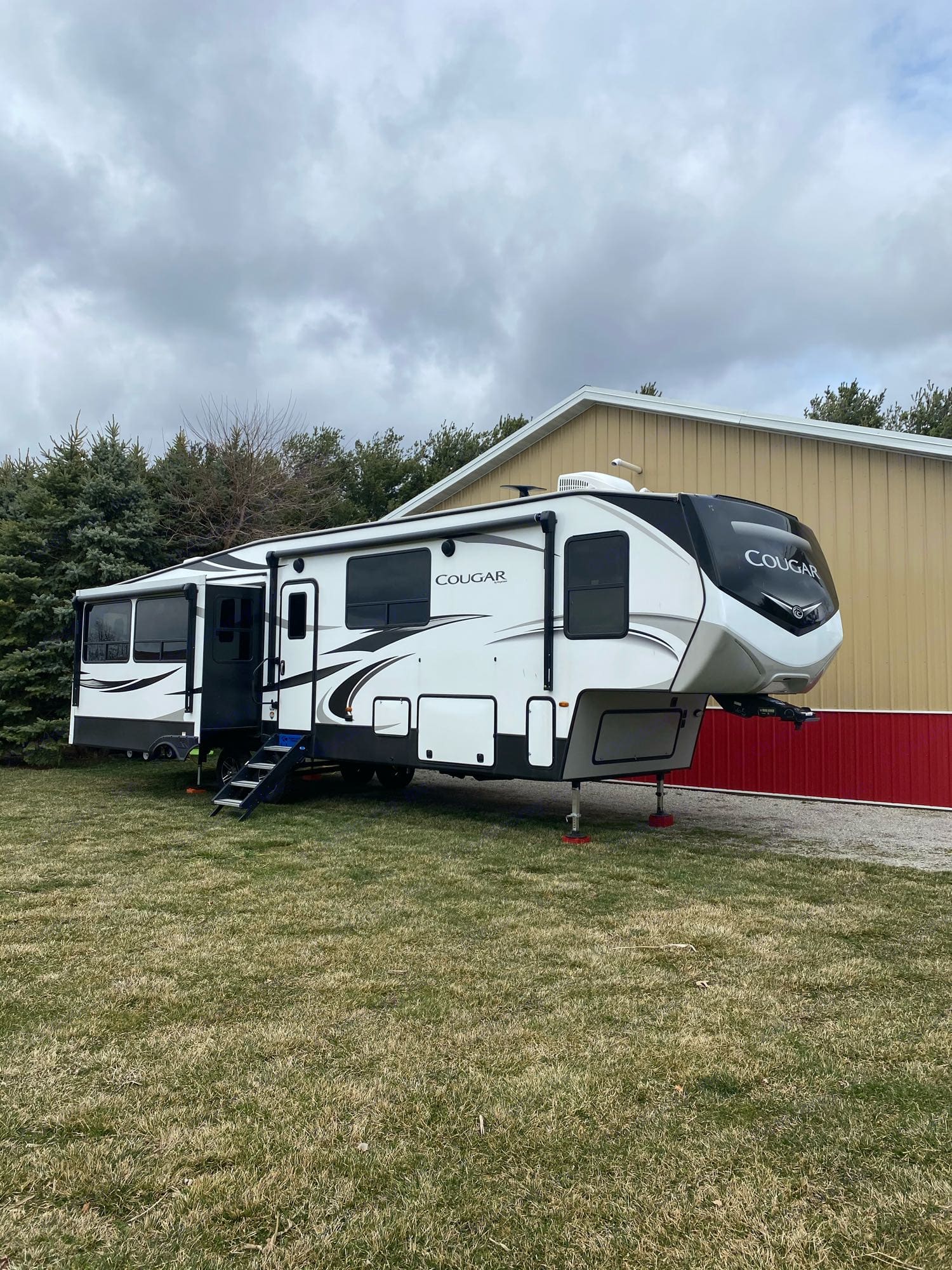 Exterior with 2 awnings with wind safe on them, lights, and outdoor speakers.. Keystone Cougar 2020