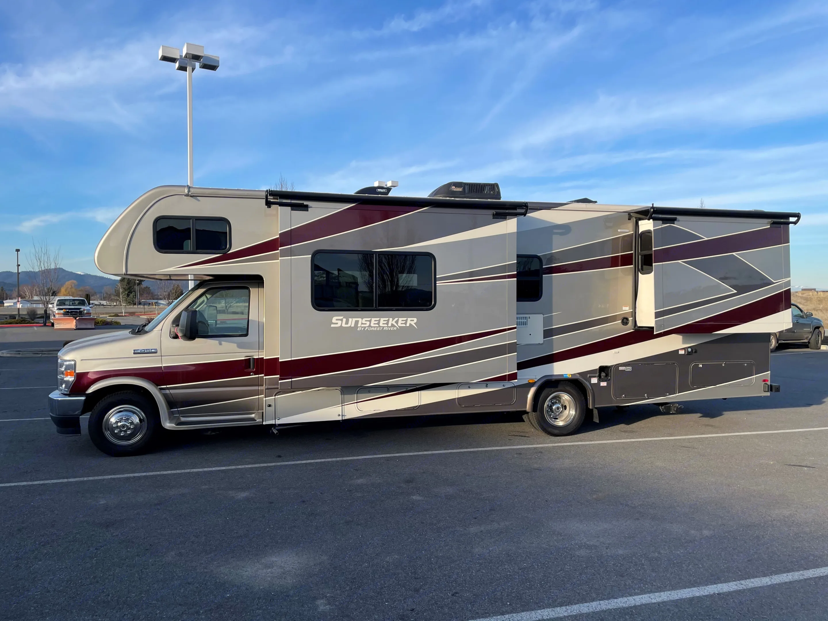 Explore with this Sunseeker rv rental: a large Class C motorhome in beige, grey, and maroon, featuring slide-outs for comfort.. Forest River Sunseeker 2021