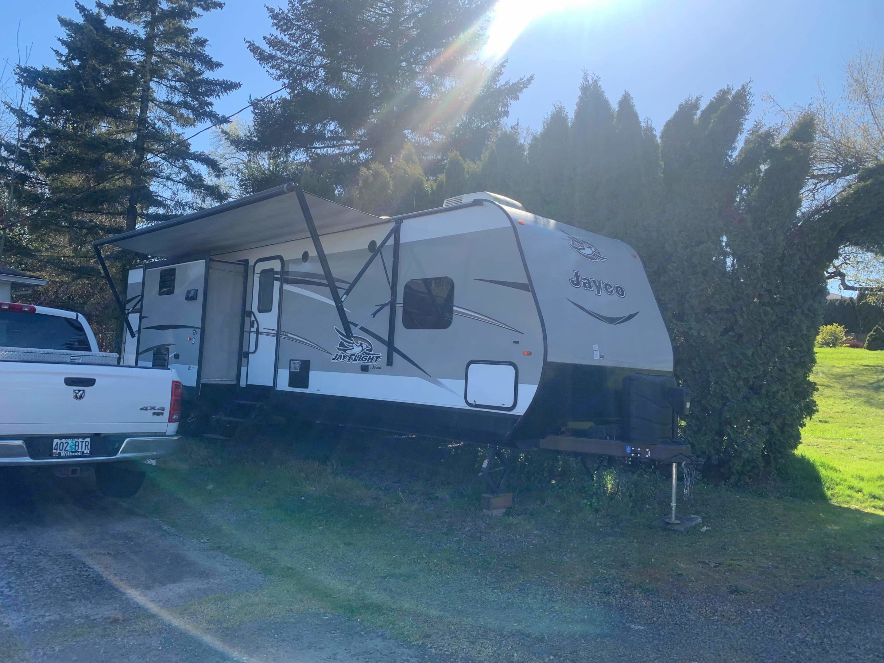 Bright day RV rental: Jayco travel trailer with awning next to a pickup truck in a sunny outdoor setting.. Jayco Jay Flight 2017