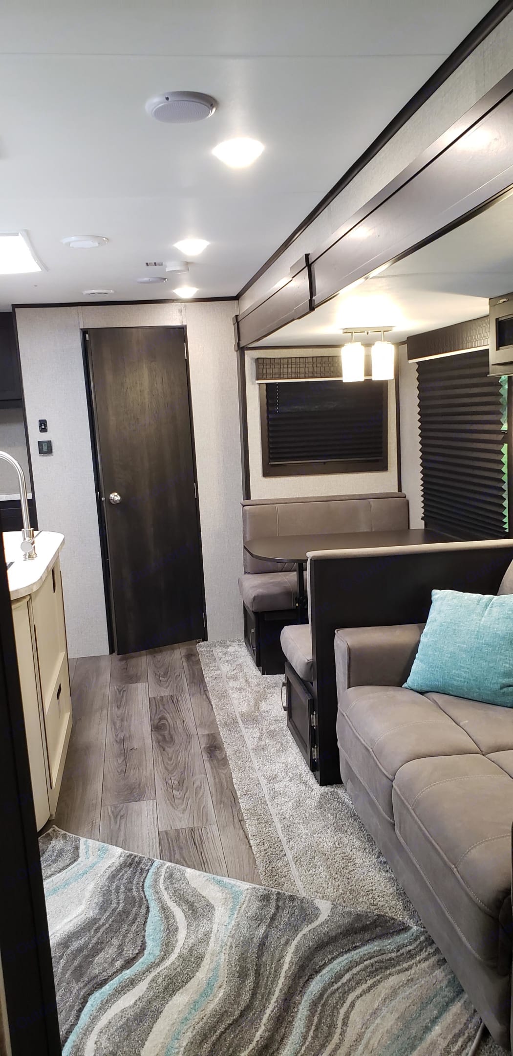 Spacious, modern RV rental interior with a cozy living area, featuring a couch, stylish rug, and bright lighting.. Jayco Jay Flight 2021
