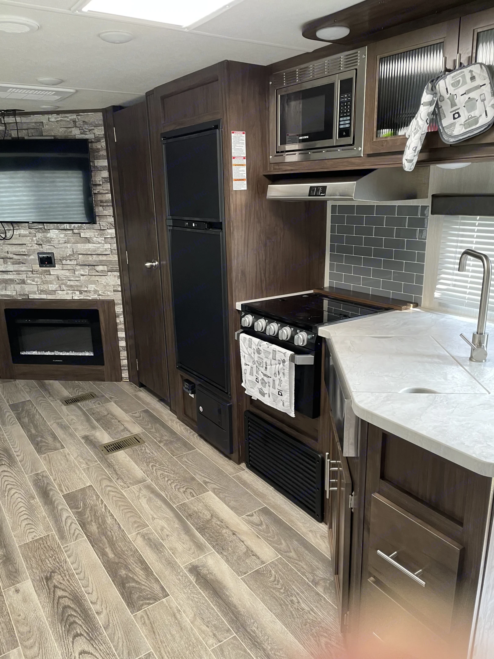 Modern RV rental interior showcasing a full kitchen, appliances, and living area with a fireplace.. Forest River 264DBH 2019