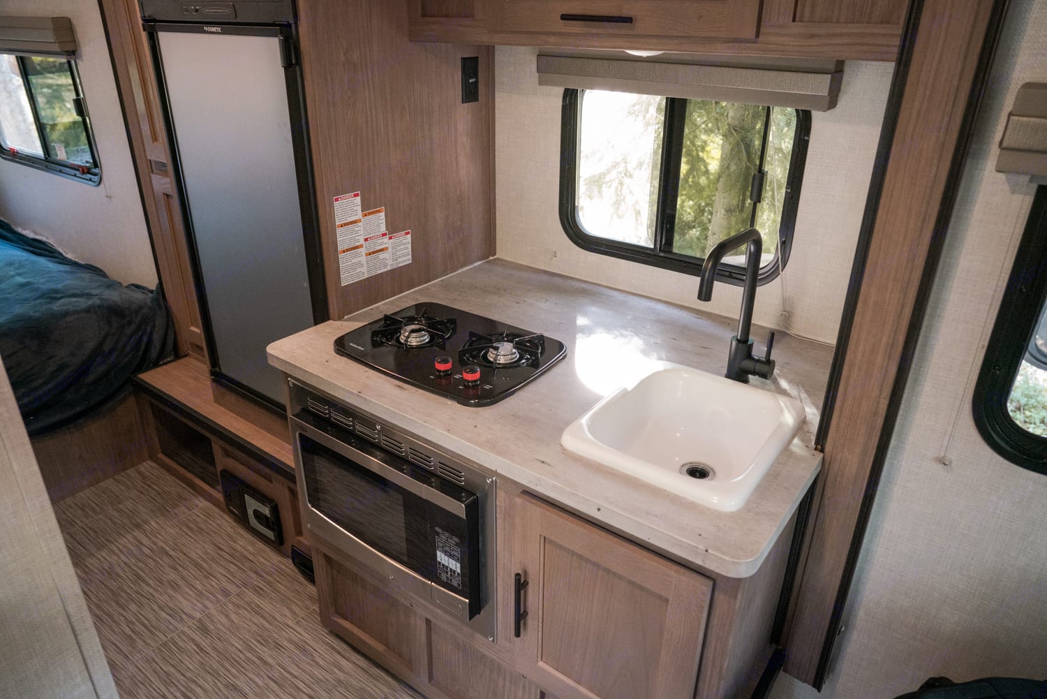 Kitchen has sink, 2-burner, micro-convection oven, and refrigerator.. Forest River No Boundries 2020