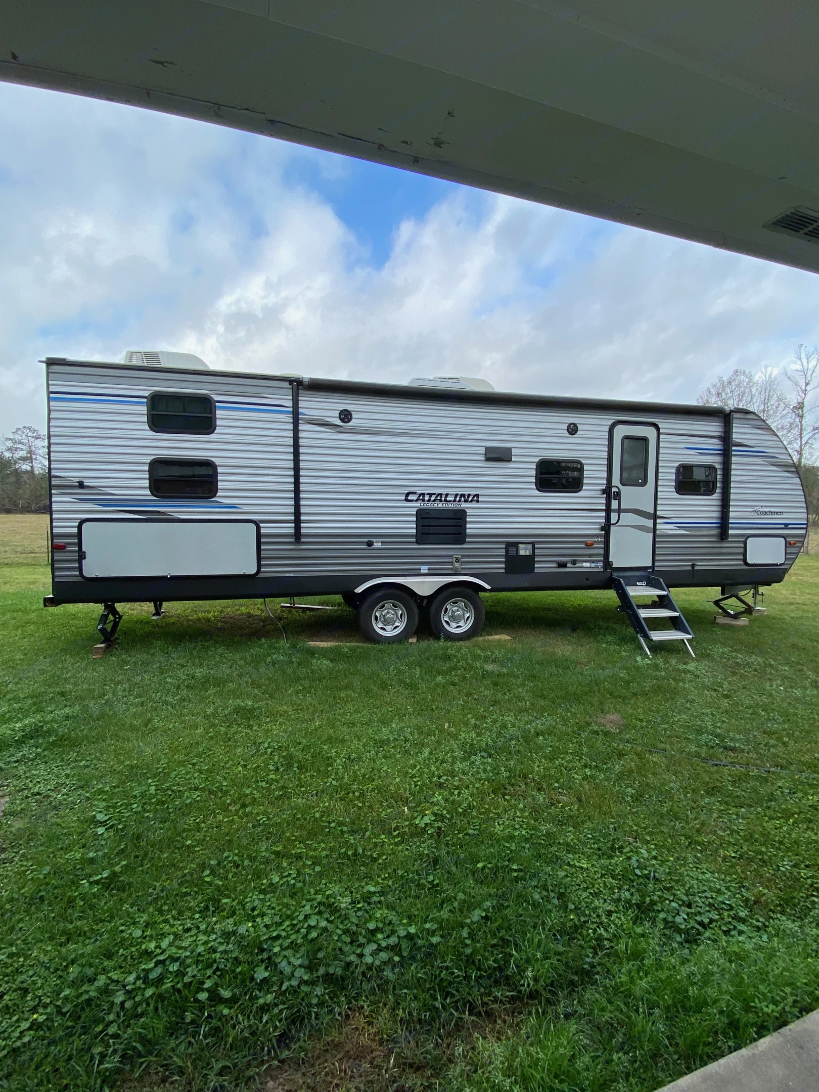 The exterior of the Catalina Coachmenn without the extended awning. The steps are extended with a rail for safe entry.. Forest River Coachmen Catalina Destination 2019