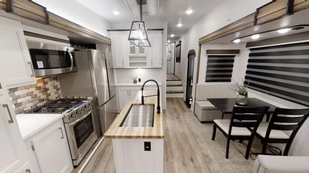 Modern RV rental interior, showcasing a bright kitchen with stainless appliances and comfortable dining.. Forest River Prime time Crusader 382mbh 2022