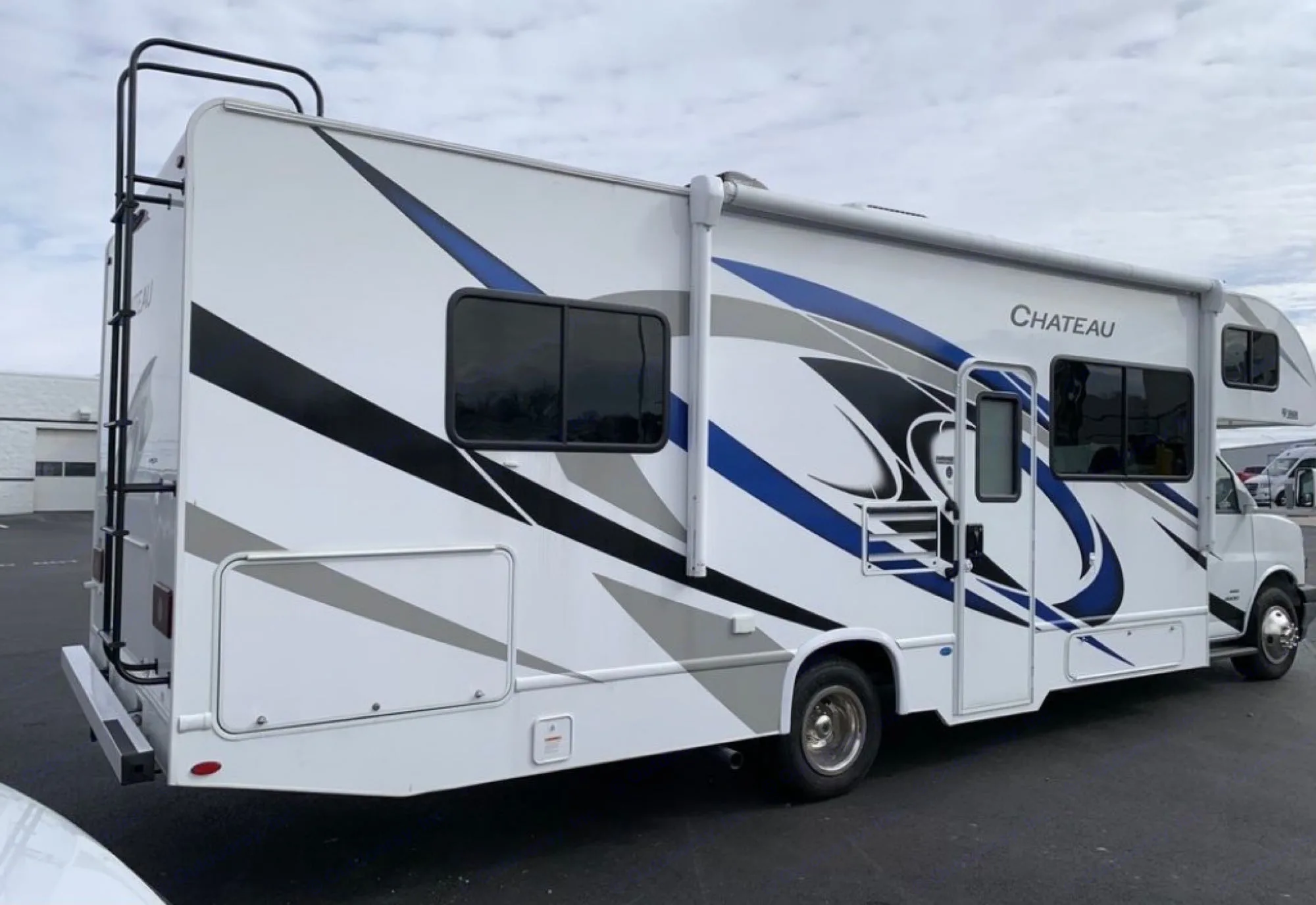 Explore with this Chateau Class C rv rental, a white motorhome with bold blue & black graphics, perfect for road trips.. Thor Motor Coach Chateau 2021