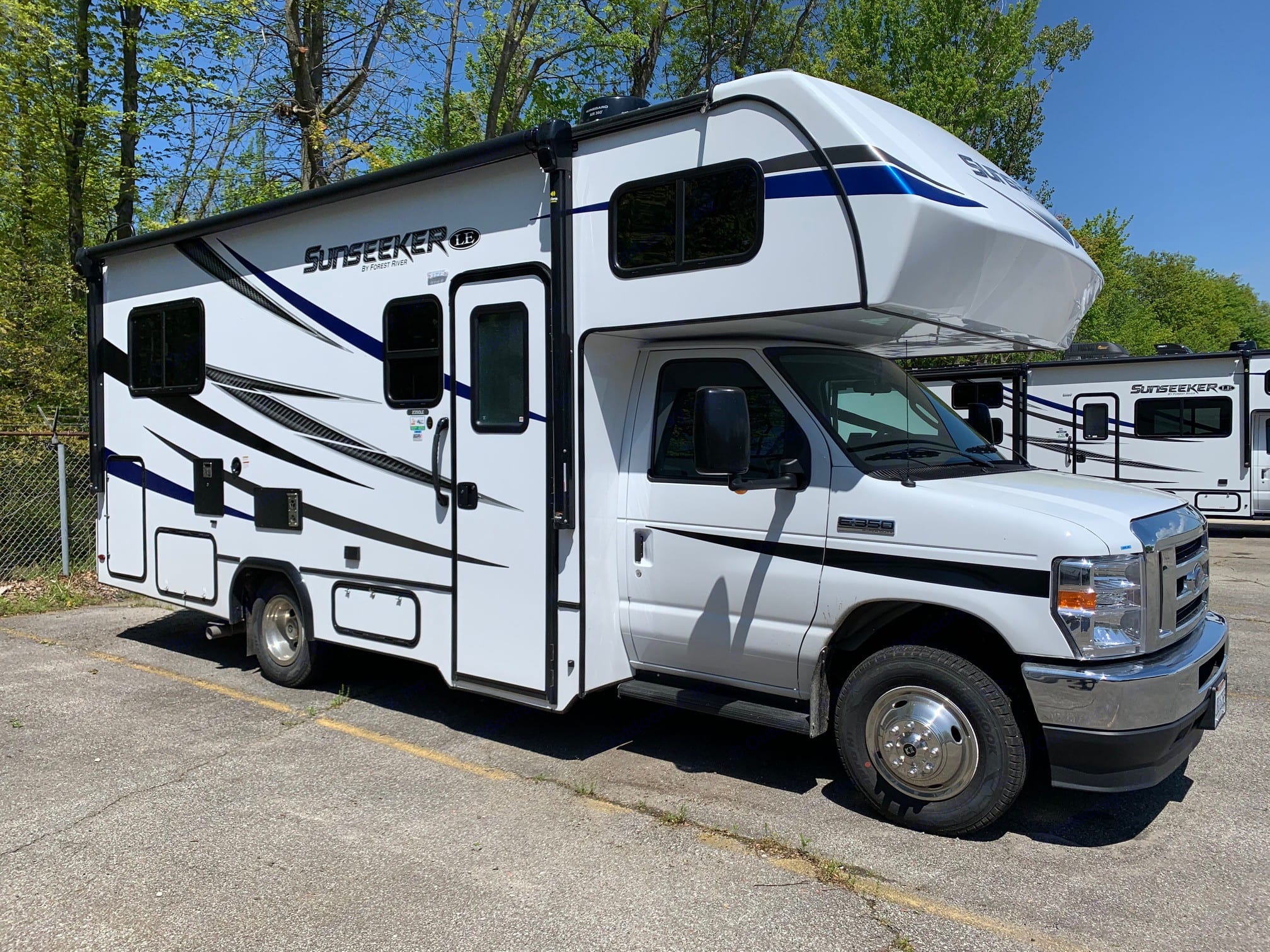This white Sunseeker Class C RV, an excellent rv rental option, is parked on asphalt, ready for your next motorhome adventure.. Forest River Sunseeker 2023