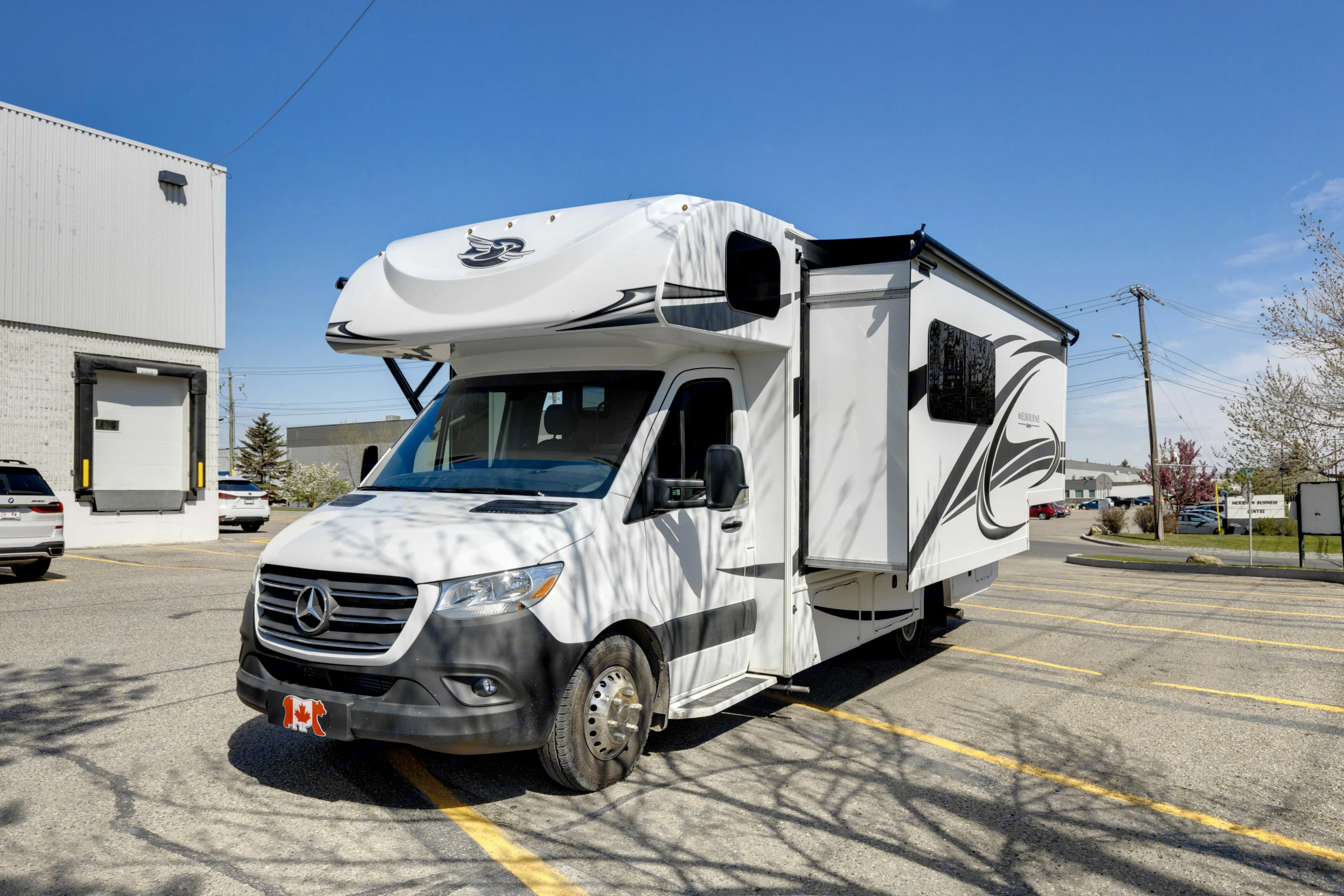 White Jayco Melbourne Class C RV rental (Mercedes-Benz Sprinter motorhome) with slide-out extended, parked outdoors on a sunny day.. Jayco Melbourne 2022