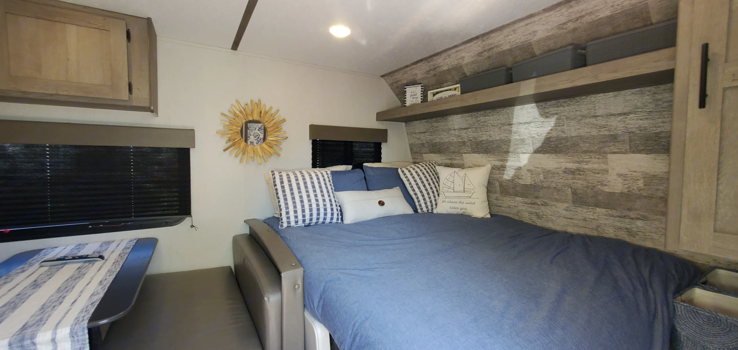 Bed w/down comforter, 4 standard pillows, decorative pillows, extra storage bins, wall hanging & linens featured in the Glamping Package Addon. Keystone RV Springdale 2021