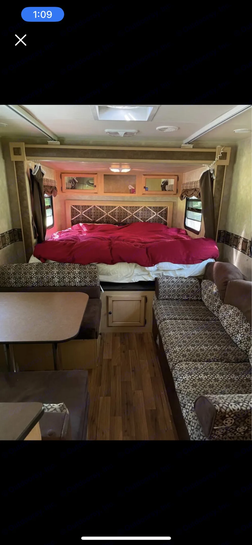 Dining table, couch, and the king size bed behind, with curtains to close for privacy. . K-Z Manufacturing Spree 2010