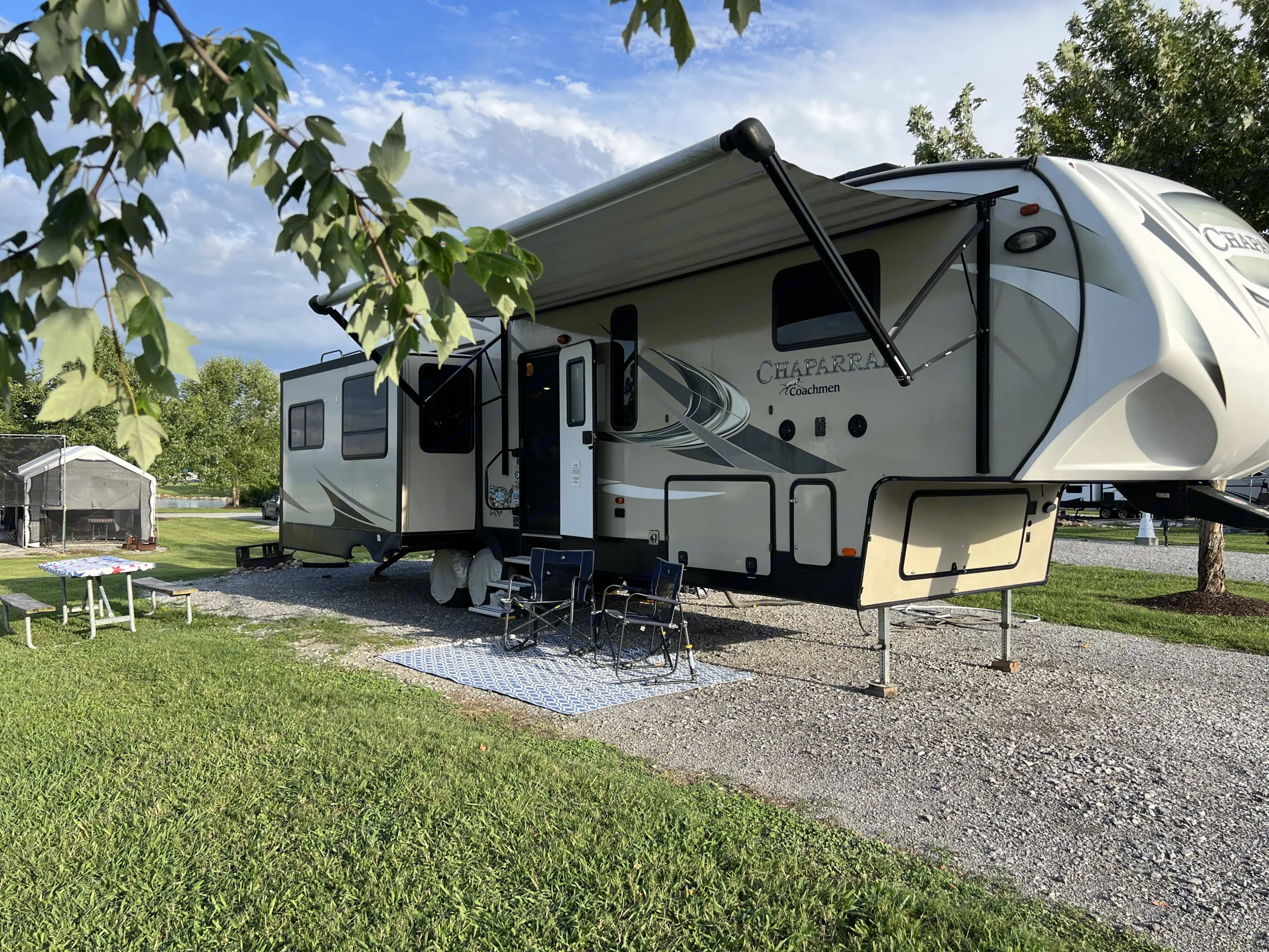 This inviting Chaparral fifth-wheel RV rental offers a perfect camping setup. Extended awning, chairs, picnic table, and lake views.. Forest River Coachmen Chaparral 2018