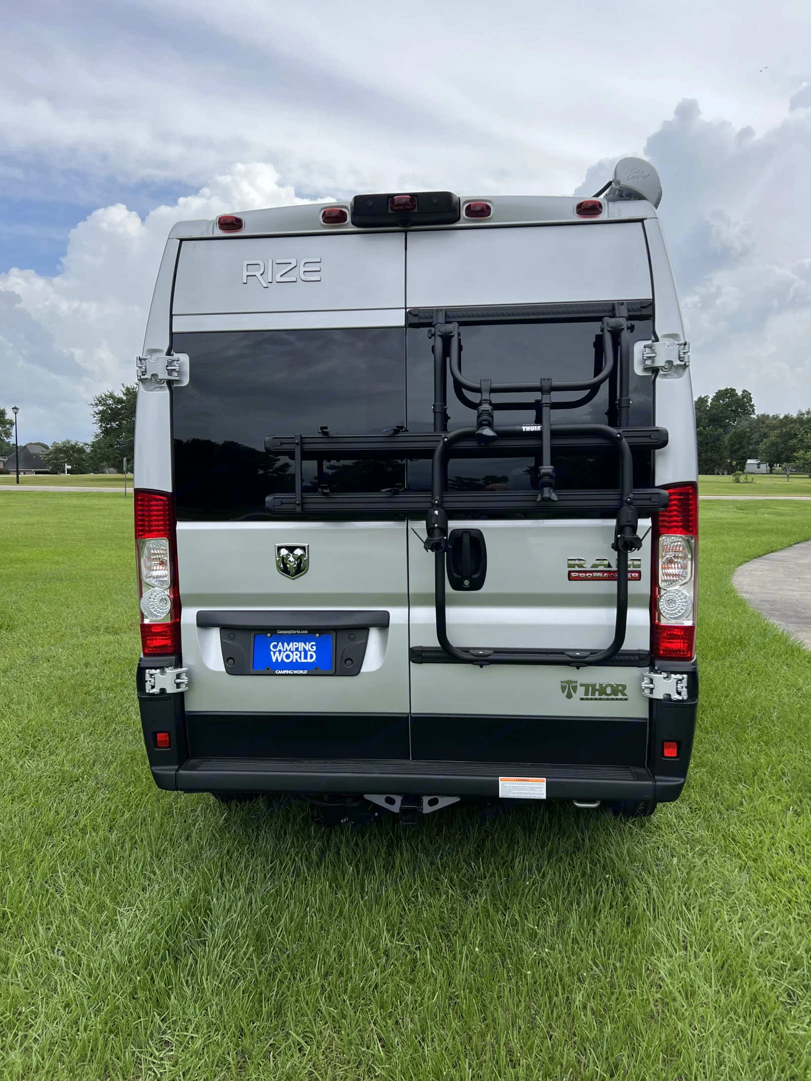Rear view of a silver Thor Rize camper van, ideal for rv rental. Features include a Thule bike rack and Camping World license plate.. Thor Rize 2022