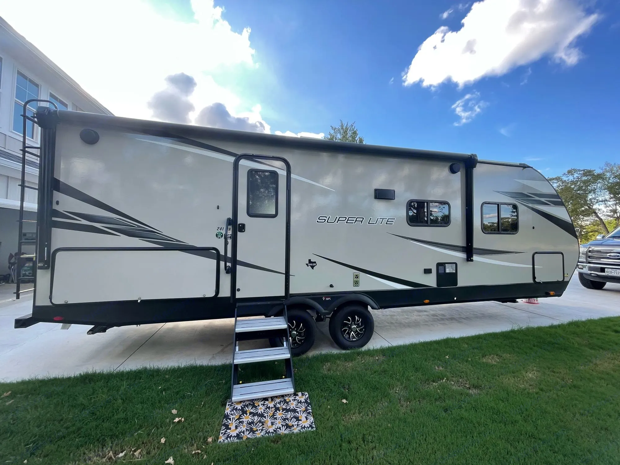 Parked on a sunny day, this Super Lite RV rental travel trailer awaits its next adventure.. Starcraft SuperLite 24BH1 2022