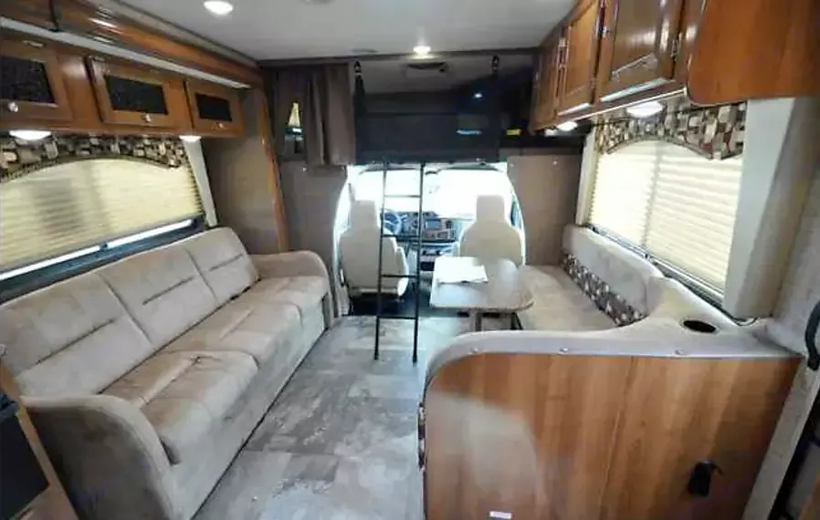 Spacious living room. Couch folds out and dinette converts to queen-size sleeping areas. Overhead bunk with privacy curtains is California king size!. Coachman Leprechaun 2018