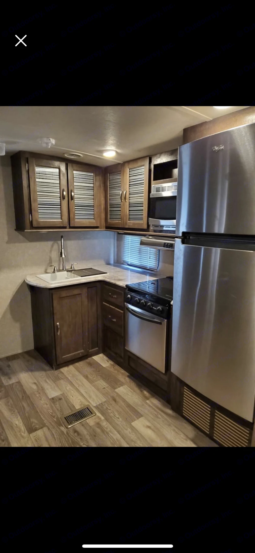 RV rental kitchen features stainless steel fridge, oven, microwave, sink, wood cabinets & flooring. Perfect for your travels.. Forest River Vibe 2017