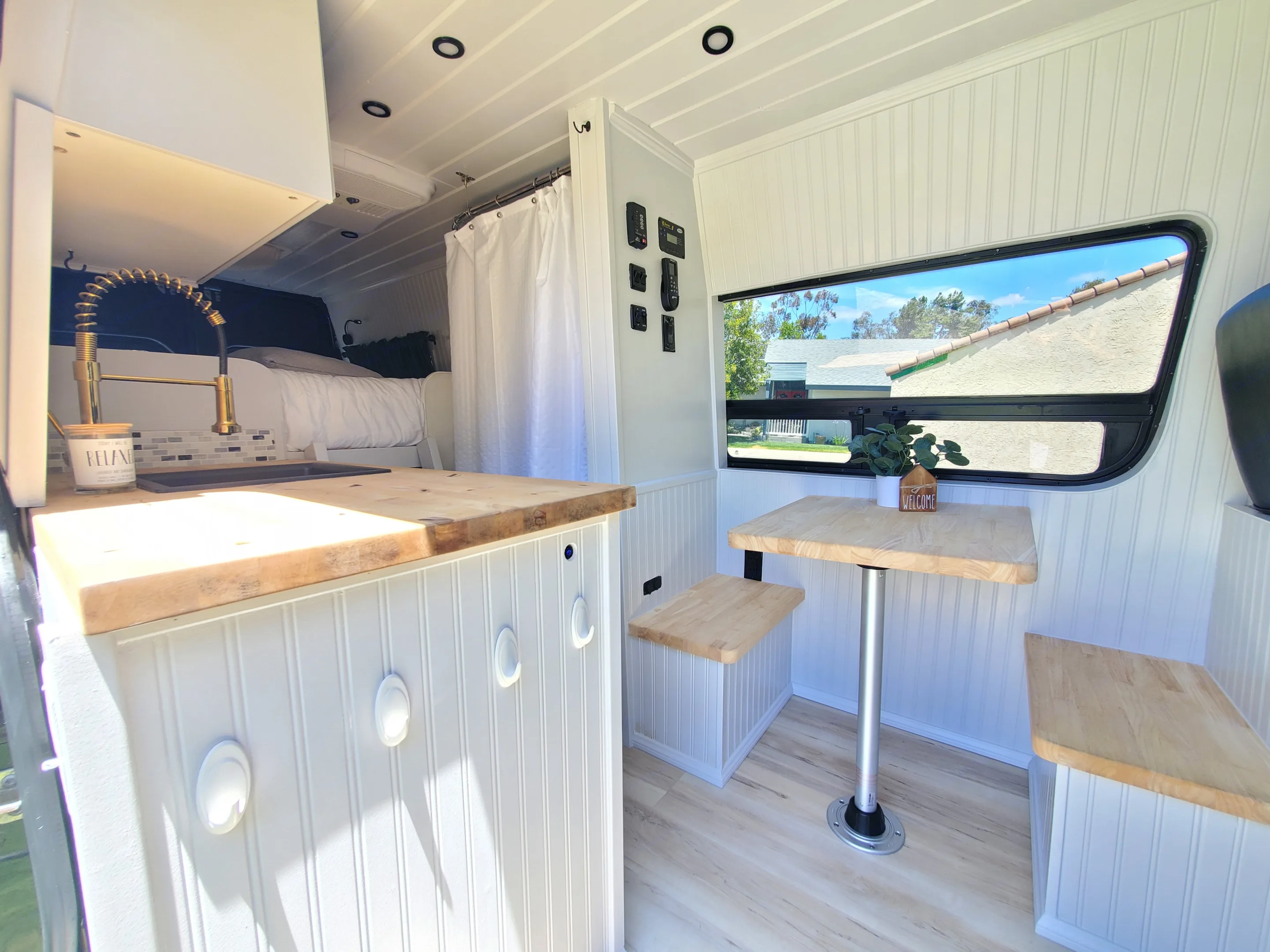 View looking in through the sliding side door to dining table, sink, shower/toilet and back to the bed.. Mercedes Sprinter 2015
