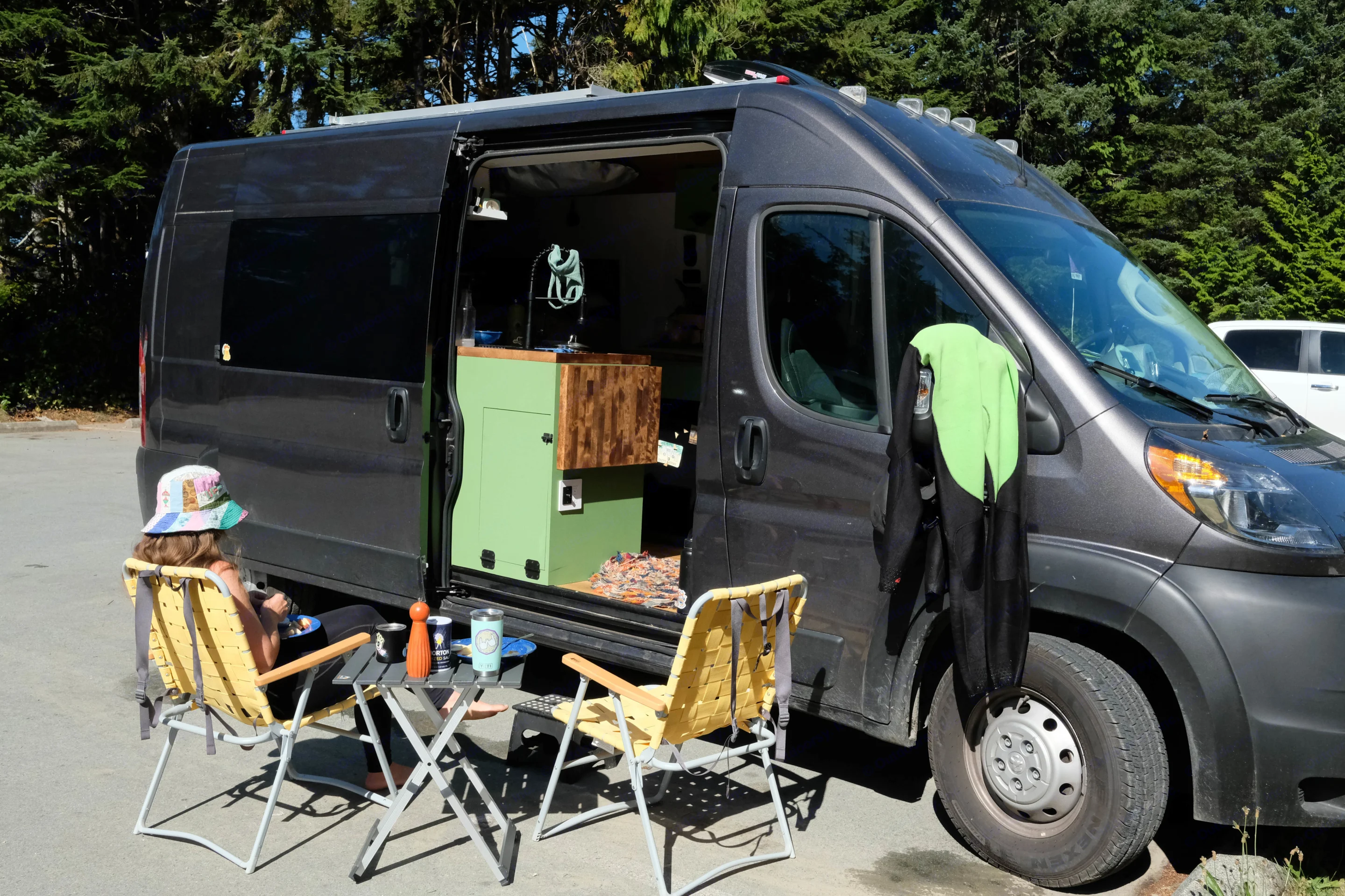 Enjoying some downtime after a surfing session. Chairs and a table are included with the rental to expand your area of relaxation.. Ram Promaster 2500 2021