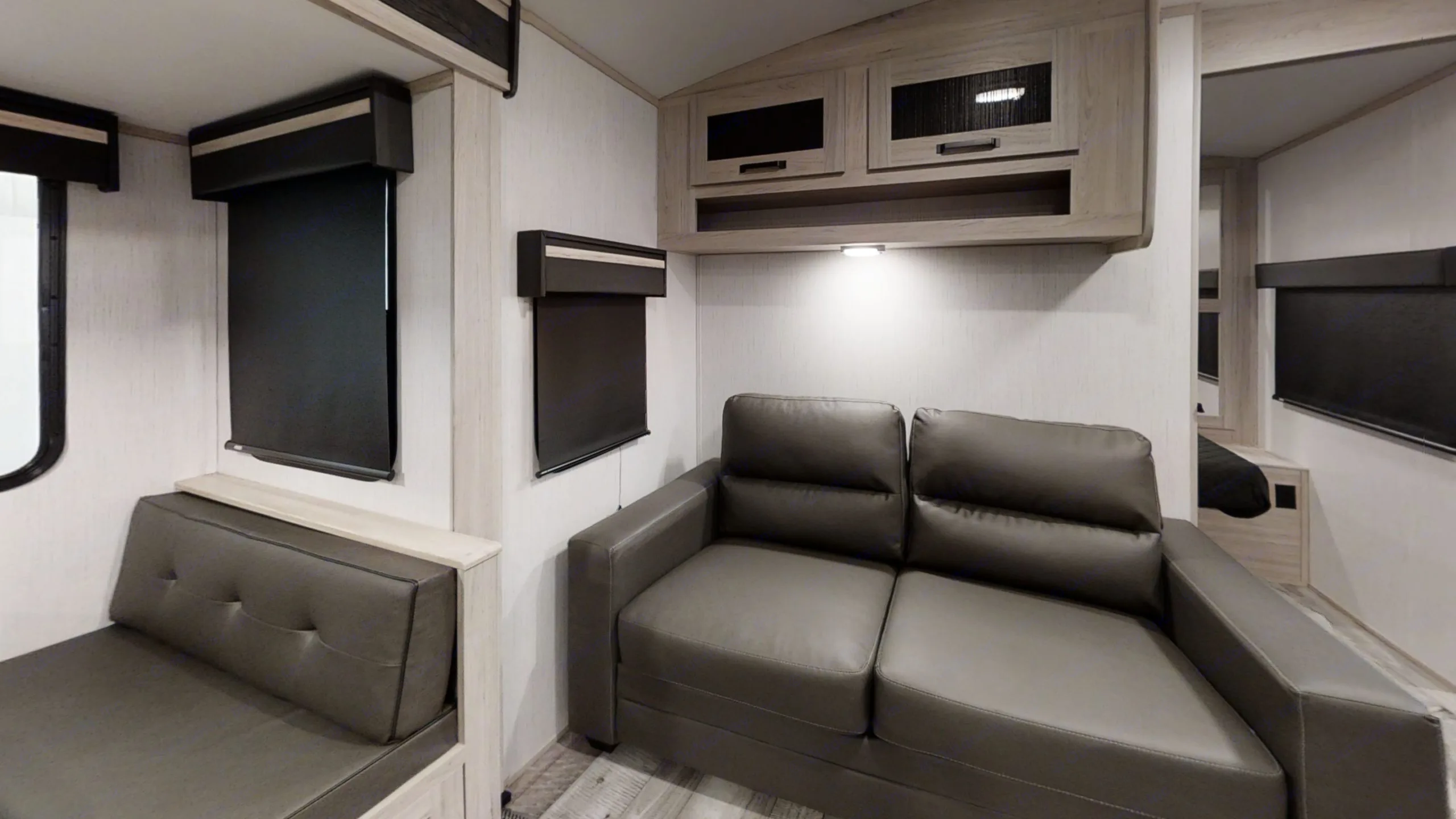 Modern RV rental interior featuring a spacious living area with seating, overhead cabinets, and window blinds.. Heartland RVs Sundance Ultra Lite 2022